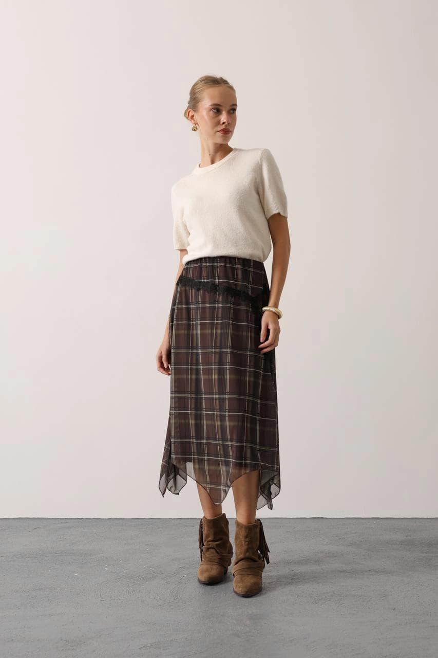 Earthy toned checked skirt, subtle transparency, gathered waist, cascading uneven hem, with ornamental dark netting.