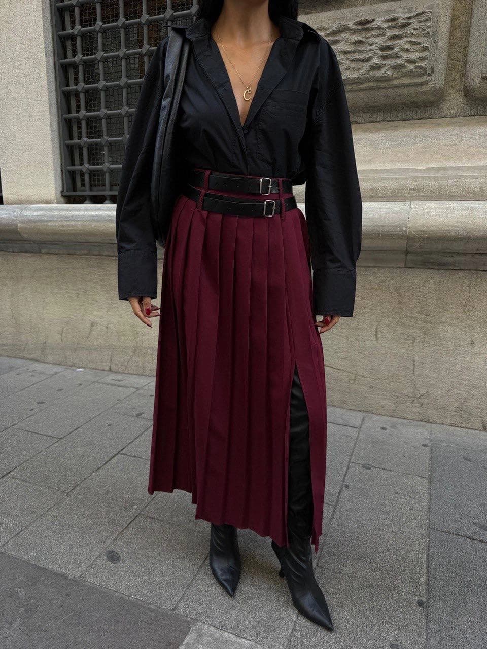 Maroon lower apparel, vertically creased, with a side division. Accented by parallel buckle bands. Chic street style.