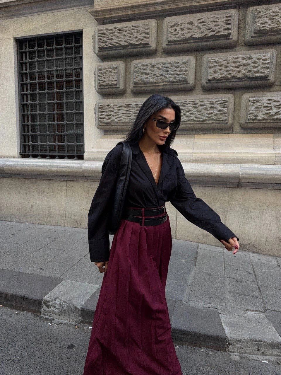 Flowing maroon A-line bottom with fine vertical texture, accented by paired dark midsection bands. Chic urban outfit.