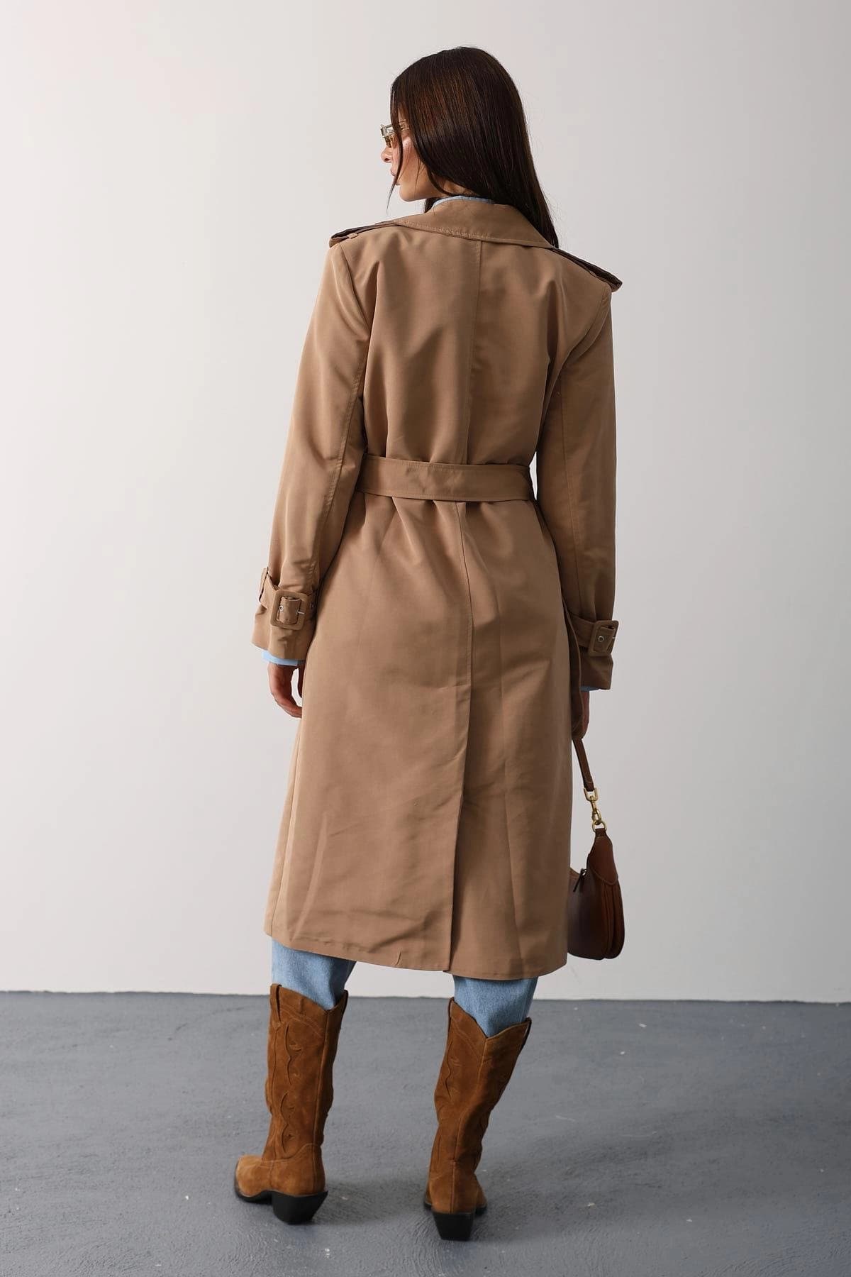 Fawn overgarment, rear view, featuring tied waist, shoulder adornments, and wrist bands. Styled with pale blue denim ...