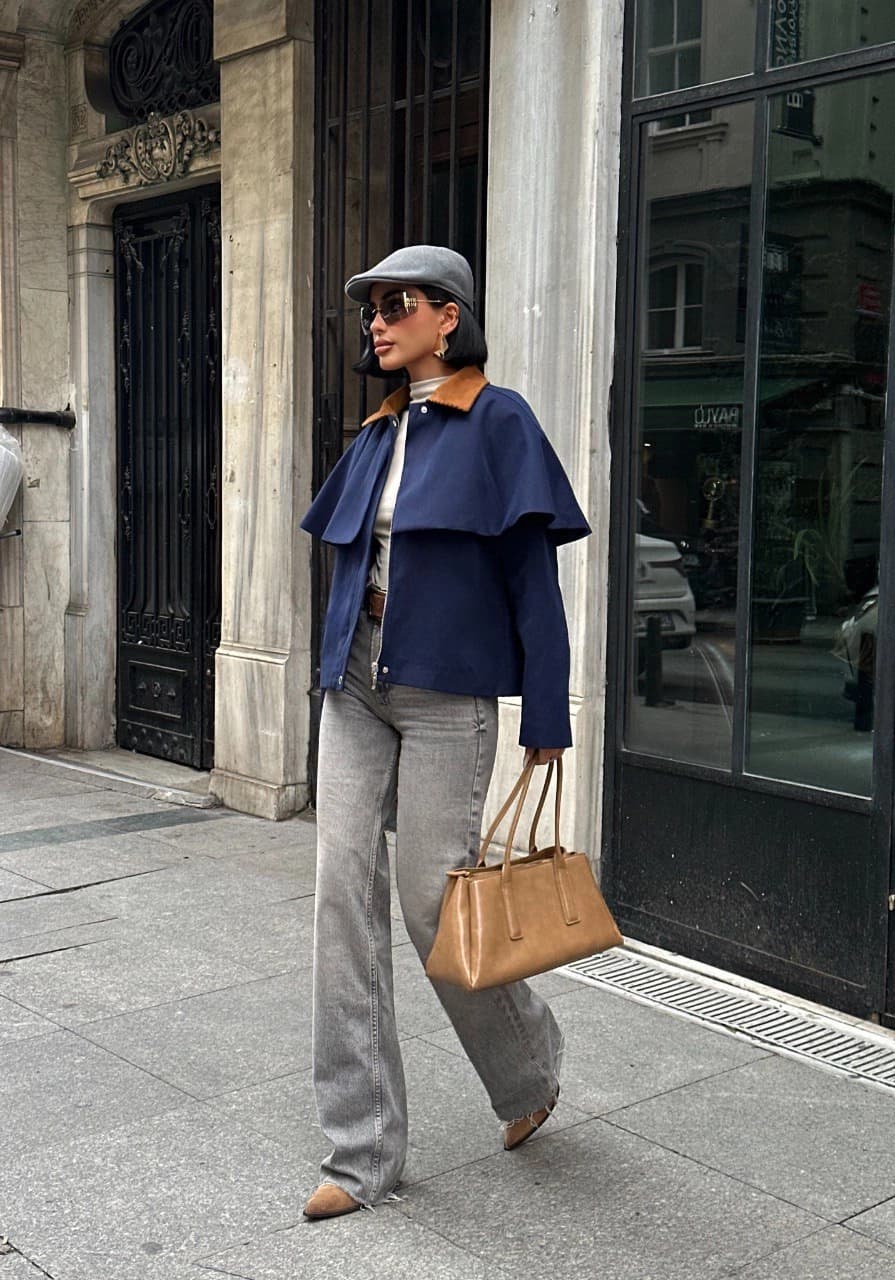 Ink-hued short outerwear for her, with tawny neck detail and a distinctive shoulder overlay. Zip-front, modern design.