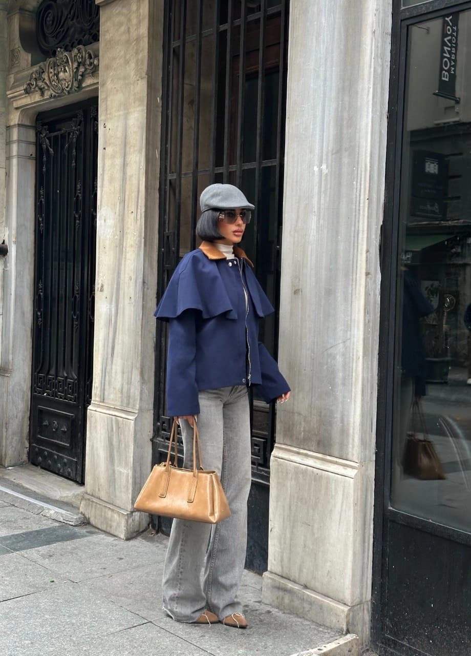 Deep indigo short topper with a russet neckband. Modern female overlay with a full zip closure, showcasing its distin...