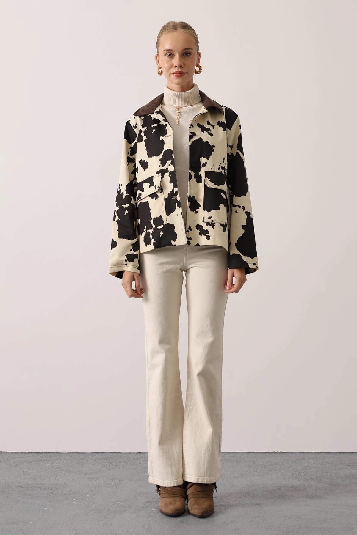 Ivory jacket with jet cowhide spots, deep brown corduroy neckline, open styling, utility patch pockets.