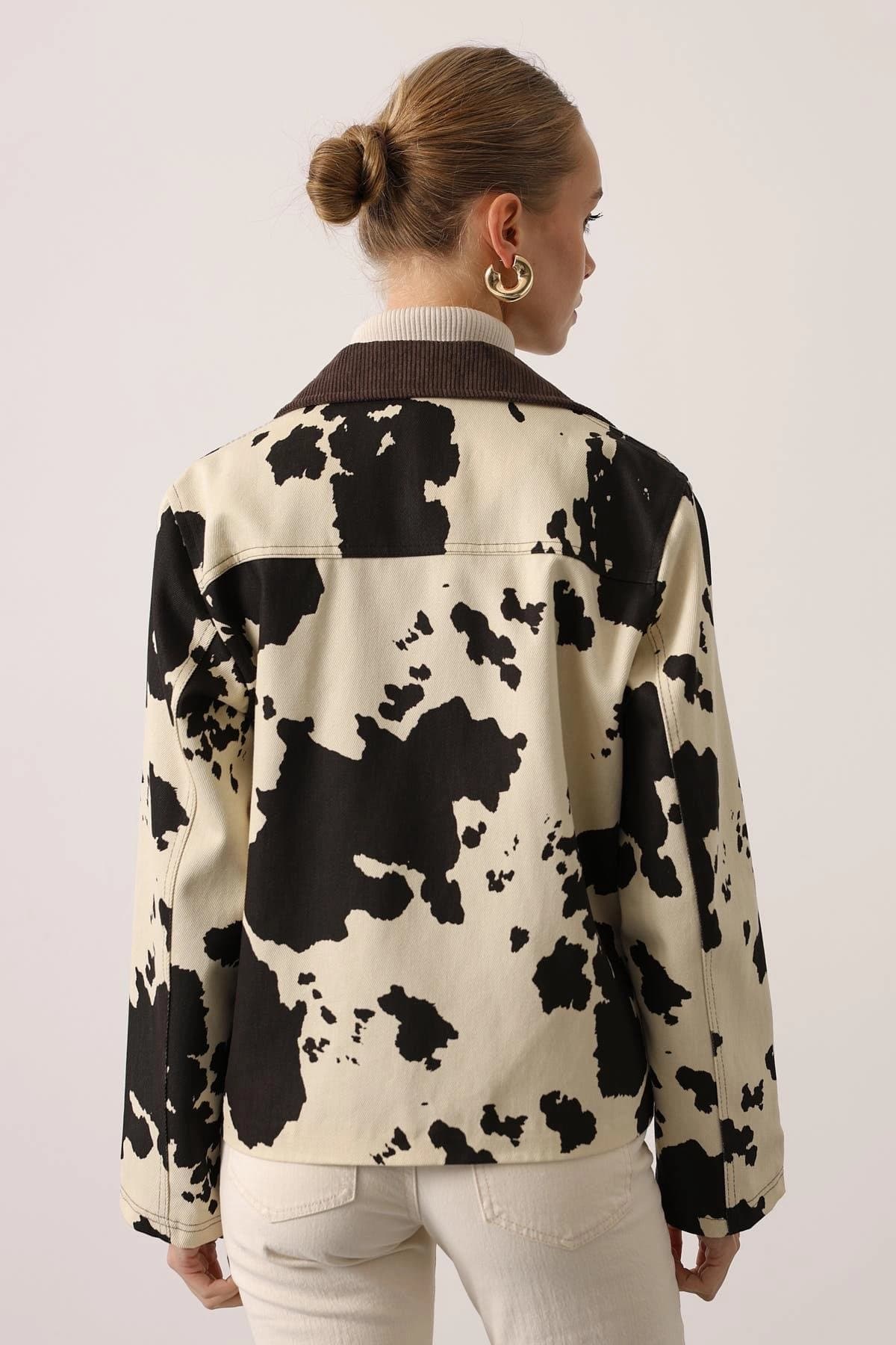 Her shell white outer garment displays sooty organic shapes, finished with a russet neck trim. Striking contemporary ...