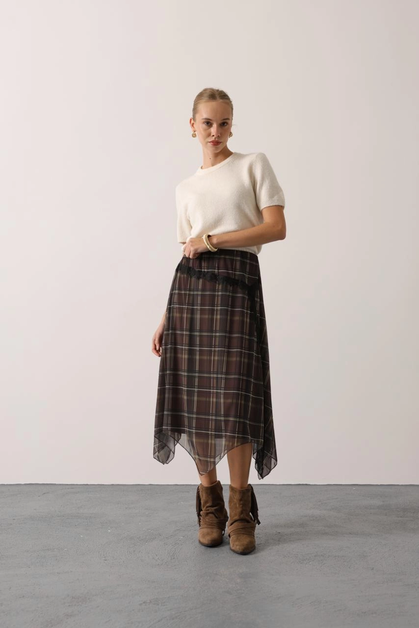 Draping sepia tartan skirt, a translucent garment with an uneven pointed hem and fine dark lace detailing.